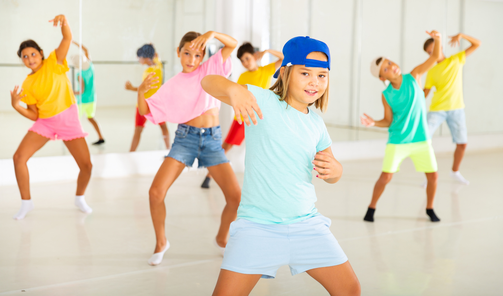 Active children dancing modern dances in choreographic studio
